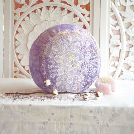 Rundes Meditationskissen in der Farbe Flieder. Schöne, florale Muster mit einem Friedenszeichen in der Mitte. Das Kissen steht aufrecht auf weißem Hintergrund.