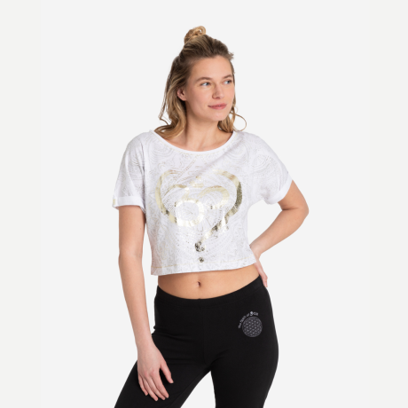 Frau trägt das Coop Shirt OM Time von  Spirit of OM. Weißes Shirt mit einem OM in Goldfolie und silbernen Mandalas. Bauchfrei. Schwarze Yogahose mit weißer Blume des Lebens 