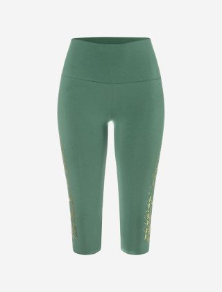 grüne Capri Leggings von The Spirit of OM. Sie hat einen goldenen Ethno-Print auf dem Bein mit einem kleinen Lotus. Hoher Bund. Bio-Baumwolle mit Turmalin. 