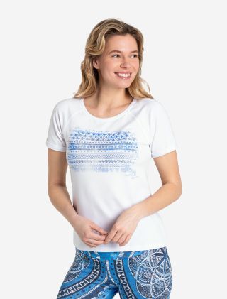 Frau mit T-Shirt in weiß und blauem Muster. Das Shirt Blue Spirit ist schön präsentiert und man sieht das blaue Muster aus Rauten, Dreiecken, Strichen und Punkten auf der Brust.