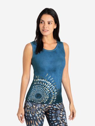 Lächelnde Frau in lässiger Haltung in dem Yoga Top Peace OM in blau. Man sieht einen schönen Mandala Print an der Hüfte mit Golddruck, der im Licht glitzert. Fair und nachhaltig von The Spirit of OM hergestellt. Mit Rosenquarz. 