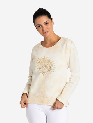 Lächelnde Frau im Sweaty OM Mani von The Spirit of OM. Dickerer, kuschelig gemütlicher Sweat-Pullover in der Farbe natur-sand-gold. Batik Optik mit einem Goldenen Mandala auf der Brust. Raglan-Schnitt. Fair und nachhaltig aus Bio-Baumwolle hergestellt. 